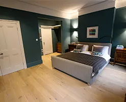 master bedroom with modern coving and wooden flooring