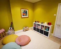tidy playroom area with mustard yellow wallpaper